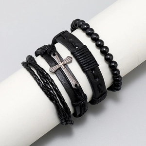 Detail of 4-piece black leather bracelet set with wooden beads and metal cross on stand