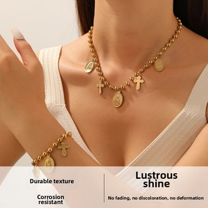 Detail of vintage gold-plated bead chain necklace with religious icon and cross pendants