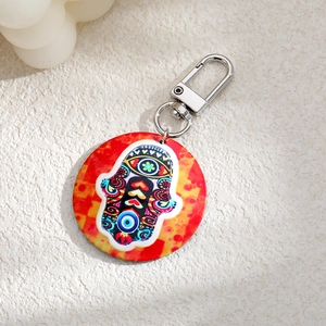 Detail of bohemian round keychain with colorful Hamsa Hand and Evil Eye print