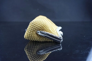 Detail der gold gewebten Abendtasche mit silbernem Metallrahmen und Verschluss