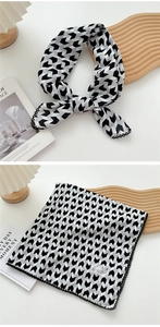 Detail of black and white geometric arrow pattern silk scarf with delicate lace trim