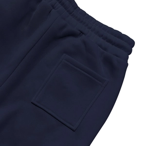 Macro shot of dark blue heavy fleece sweatpants showing rear waistband and deep cargo pocket