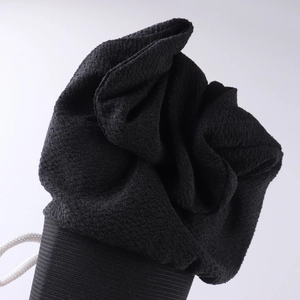 Close-up of black exfoliating bath glove texture with durable white hanging loop