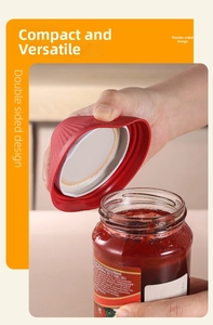 Dettaglio dell'apribarattoli in silicone rosso mentre apre un vasetto di marmellata