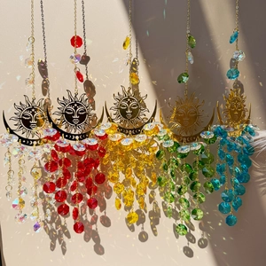 Five crystal suncatchers with metal sun moon face designs casting rainbow light spots