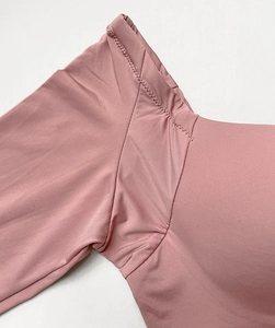 Detail of side-wing stitching and high-elastic fabric on a pink underarm bra area
