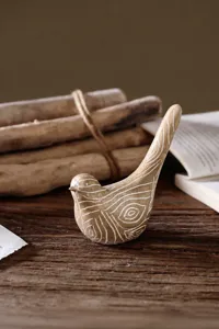 Macro shot of bird ornament detail showing white grain texture on dark resin wood finish