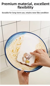 Close-up of toast-shaped cellulose sponge wiping a dirty ceramic plate in the kitchen