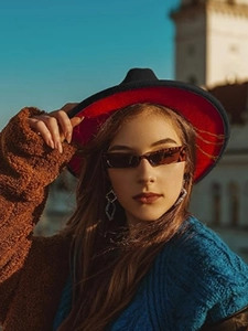 Fashionable felt fedora hat in black and red paired with blue cable knit sweater