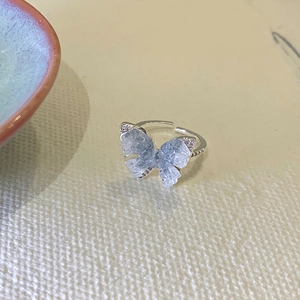 Detailed view of silver butterfly ring featuring gradient blue crystals and small rhinestones