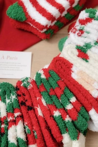 Close-up of thick coral fleece Christmas socks with festive striped patterns and soft texture