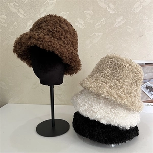 Detail of curly lamb wool bucket hats in brown, beige, white, and black colors