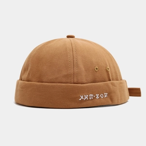 Detail of caramel canvas docker hat featuring white Russian hip-hop embroidery