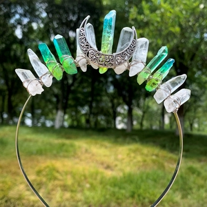 Detail of handmade crystal crown with moon ornament and green gemstone accents