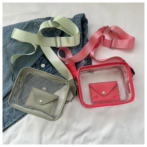 Detail of light green and pink clear PVC crossbody bags with wide fabric straps