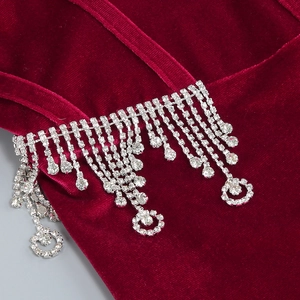 Detail of silver rhinestone tassels on luxurious burgundy velvet evening gown fabric