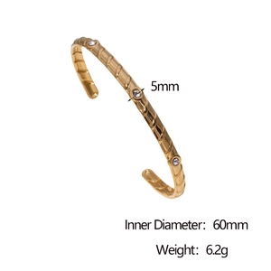 Detail view of 5mm wide gold-plated stainless steel bangle with three clear zircon stones