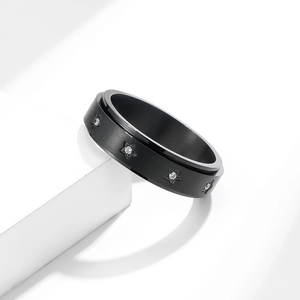 Black brushed stainless steel spinner ring with star shaped crystal inlays on white blocks