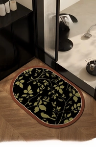 Detail of oval diatom mud bath mat with medieval bird and leaf pattern on wooden floor