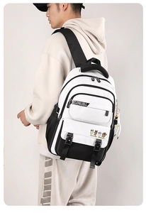 Side view of black and white large capacity backpack worn by a model on grey background