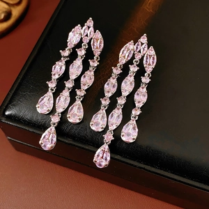 Detailed macro view of pink zircon teardrop tassel earrings with silver finish plating