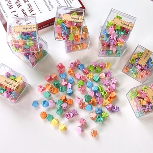 Macro shot of colorful mini flower and fruit hair claws in a clear gift box