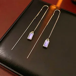 French vintage gold drop earrings with purple rectangular enamel pendants on leather