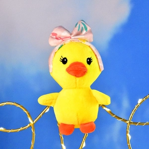 Close-up of a cute plush yellow duck with a pink floral headband bow