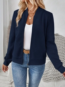Close-up of dark blue jacket showing unique 3D rhombic texture and zipper detail