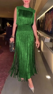 Détail d'une robe longue verte sans manches élégante avec des franges et un col rond