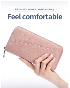 Close-up of pink pebbled leather wallet featuring diagonal stitching and silver zipper detail