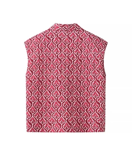 Detailed view of pink quilted vest with white floral geometric patterns and a stand collar