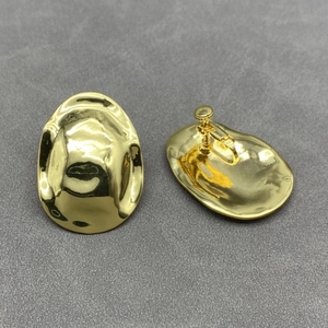Detailed view of irregular geometric gold clip-on earrings with screw-back mechanism