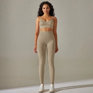 Detail of sand color seamless knitted yoga set with cross back bra and leggings