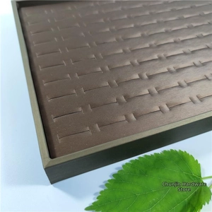 Close-up of deep brown velvet ring display tray with multiple slots and textures