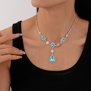 Detail of vintage silver necklace with light blue teardrop gemstone and white crystals