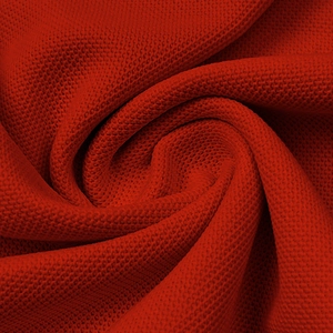 Macro close-up of breathable red piqué knit fabric texture on a men's polo shirt