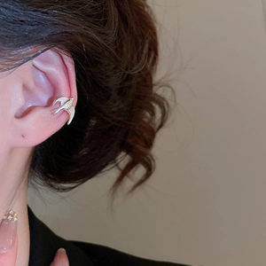 Close-up of elegant silver bird-shaped ear cuff with sparkling zircon and pearl accents
