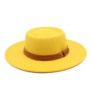 Close-up of bright yellow wool fedora hat with brown leather strap and silver studs