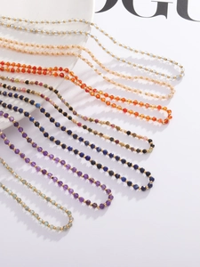 Detailed close-up of faceted natural stone beaded necklace with small gold metal spacers