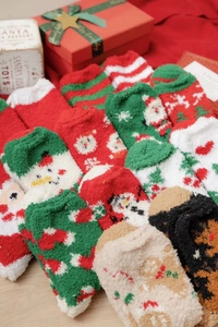 Close-up of thick Christmas coral fleece socks in a festive holiday gift arrangement