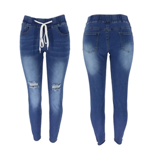 Vue à plat d'un jean slim bleu avec taille à cordon et détails déchirés aux genoux