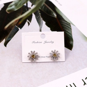 Close-up of daisy stud earrings with S925 silver needles on a fashion jewelry card