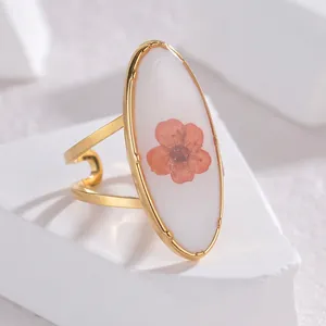 Detailed macro of oval preserved flower ring with gold-plated adjustable split band