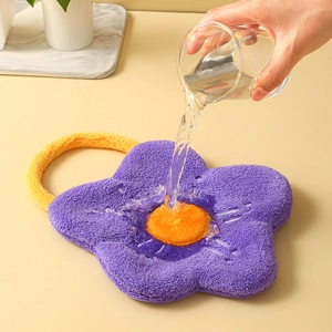 Strong water absorption demo of a flower-shaped purple chenille hand towel with hanging loop