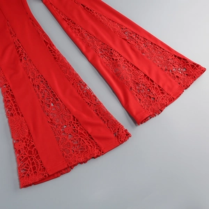 Détail du patchwork en dentelle rouge sur le bas du pantalon évasé à motifs floraux