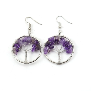 Close-up of handmade silver wire tree of life earrings with purple amethyst stones