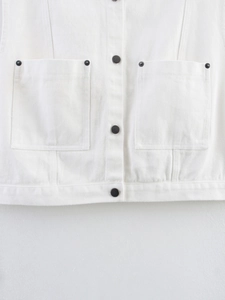 Detail view of white denim vest showing metal buttons and symmetrical cargo pockets
