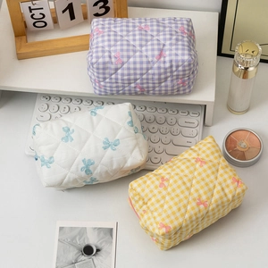 Quilted makeup bags with bow prints in purple, white, and yellow plaid patterns