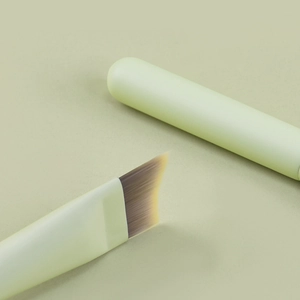 Minimalist ultra-thin crescent foundation brush with soft synthetic bristles and green handle